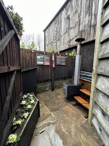 une arrière-cour avec une clôture en bois et un radiateur dans l'établissement Bertie's Retreat, à Foolow
