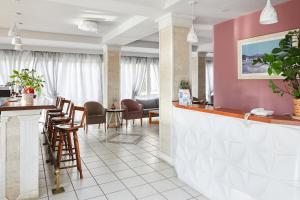 a restaurant with a bar with chairs and tables at Klonos Anna in Egina