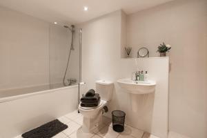 a white bathroom with a toilet and a sink at West End Escape - Prime Location in Glasgow
