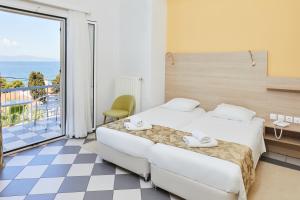 a hotel room with two beds and a balcony at Klonos Anna in Egina