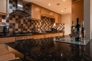 a kitchen with a black and white tiled wall at West End Escape - Prime Location in Glasgow