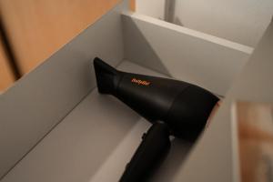 a black hairdryer in a white drawer at West End Escape - Prime Location in Glasgow