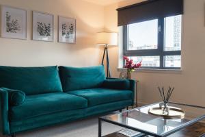 un soggiorno con divano verde e tavolo in vetro di West End Escape - 5 Star Luxury - Prime Location a Glasgow