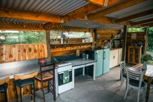 an outdoor kitchen with a stove and a table and chairs at HighlandsView in Swellendam