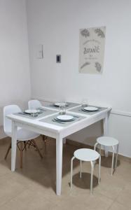 una mesa blanca con dos sillas y una mesa con gafas. en Casa Isa en San Juan