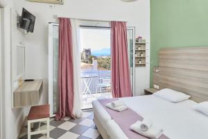a bedroom with a bed and a window with a view at Klonos Anna in Egina