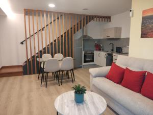 a living room with a couch and a table and a kitchen at Armada Sacra A Teixeira in Ourense
