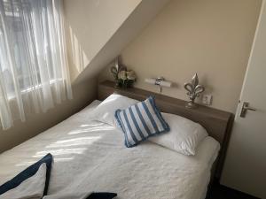 ein Schlafzimmer mit einem Bett mit zwei Kissen darauf in der Unterkunft Fisherman's House by Hofstad Hotels in Scheveningen