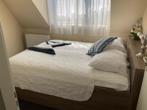 ein Bett mit weißer Bettwäsche, blauen Kissen und einem Fenster in der Unterkunft Fisherman's House by Hofstad Hotels in Scheveningen