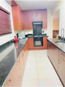 Summerstrandにある2 Private Bedrooms - homestayの木製のキャビネットとコンロ付きオーブンを備えたキッチン +7枚の写真