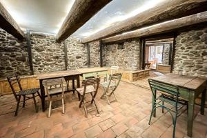 ein Zimmer mit Tischen und Stühlen und einer Steinmauer in der Unterkunft Michelsberger Haus in Michelsberg