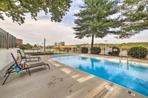 a swimming pool with two chairs next to at Welcoming Downtown Branson Cottage with Pool Access! in Branson