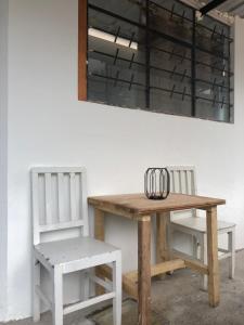 einen Holztisch und zwei Stühle neben einer Wand in der Unterkunft Tiny apartment in the city rooftop terrace in Baños