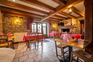 a restaurant with tables and chairs and a fireplace at La bergerie in Azet
