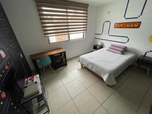 1 dormitorio con cama, escritorio y ventana en Equiped private rooms at nice residence in Morelia, en Morelia