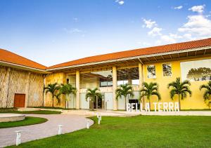 ein großes gelbes Gebäude mit Palmen davor in der Unterkunft Bella Terra Laguna Azul Resort & Spa in Sauce