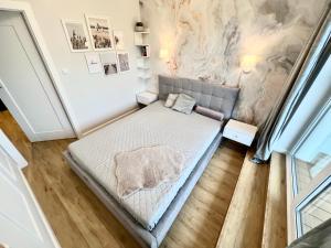 a bedroom with a bed and a wall with paintings at Apartament Superior & SPA Marina Dziwnów in Dziwnów