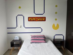 1 dormitorio con 1 cama con letrero de arax en la pared en Equiped private rooms at nice residence in Morelia, en Morelia