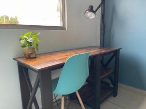 una silla azul sentada frente a un escritorio de madera en Equiped private rooms at nice residence in Morelia, en Morelia