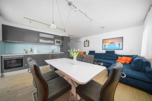 a living room with a table and a blue couch at Olive Balcony Vodice-Srima in Srima