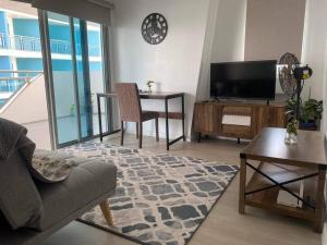 a living room with a couch and a tv and a table at Haldis Suites in San Fernando