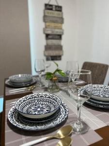 a table with plates and wine glasses on it at Haldis Suites in San Fernando