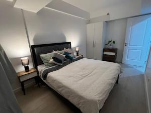 1 dormitorio con 1 cama con 2 lámparas y puerta en Haldis Suites, en San Fernando