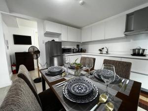 a kitchen with a table with plates and wine glasses at Haldis Suites in San Fernando