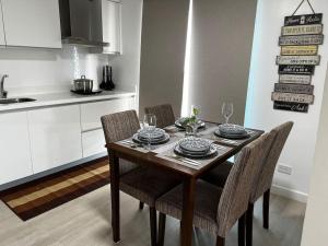 a dining room table with chairs and a kitchen at Haldis Suites in San Fernando