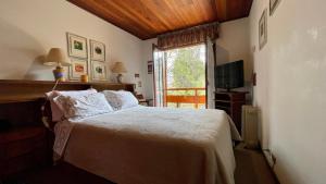 Un dormitorio con una cama grande y una ventana en Apê 3 quartos mega charmoso 600 m do centrinho, en Campos do Jordão