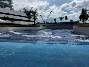a pool of blue water with palm trees at Haldis Suites in San Fernando