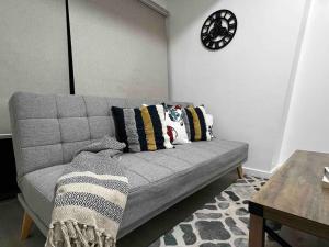 a living room with a couch and a clock on the wall at Haldis Suites in San Fernando