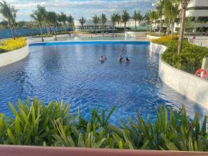 a pool at a resort with people in the water at Haldis Suites in San Fernando