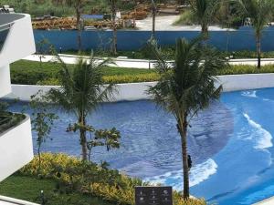 a swimming pool with two palm trees in the water at Haldis Suites in San Fernando