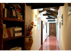 einen Flur in einem Gebäude mit Bücherregalen und einer Tür in der Unterkunft Apartamentos Rurales Víctor Chamorro del Arco in Hervás