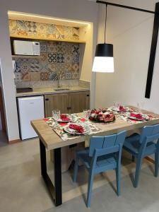 uma cozinha com uma mesa de madeira e cadeiras azuis em Eco Resort Quinta Santa Bárbara em Pirenópolis