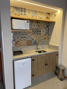 une cuisine avec un évier et un micro-ondes dans l'établissement Eco Resort Quinta Santa Bárbara, à Pirenópolis 12 autres photos