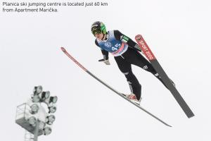 a skier is in the air while jumping at Apartma Marička in Križe