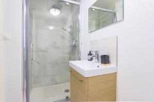 y baño con lavabo y ducha. en Appartamento Uno Avec Parking Privé Gratuit, en Arras