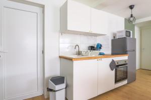 a kitchen with white cabinets and a sink at Appartamento Uno Avec Parking Privé Gratuit in Arras