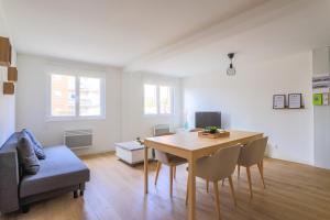 uma sala de estar com uma mesa e cadeiras e um sofá em Appartamento Uno Avec Parking Privé Gratuit em Arras