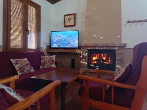 a living room with a fireplace and a tv at Casa José in Ardales