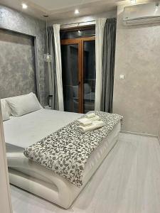 a bedroom with a bed with a black and white blanket at Elegant Stay in the Heart of Plovdiv Old Town in Plovdiv