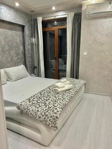 a bedroom with a bed with a black and white blanket at Old Town Stylish Flat in Center Plovdiv in Plovdiv