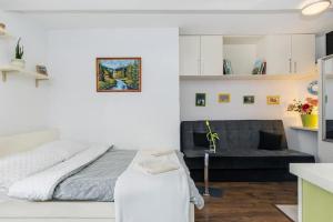 a white bedroom with a bed and a couch at Cosy Studio Apartment in Krakow