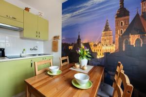 a kitchen with a table with a painting of a city at Cosy Studio Apartment in Krakow