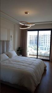 una camera con un grande letto e una grande finestra di Chez Miguel appartement Casablanca avec piscine a Casablanca