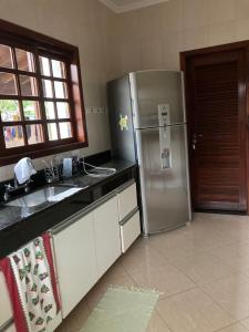 a kitchen with a stainless steel refrigerator and a sink at Hostel Re & Mar in Caraguatatuba
