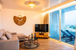 a living room with a couch and a flat screen tv at KALIMA APARTMENT in Puerto del Carmen