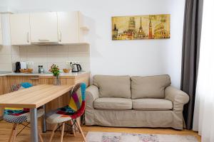 kuchnia i salon z kanapą w obiekcie Pastel Apartments w Braszowie
